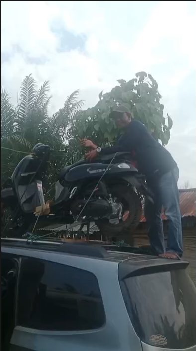 Sopir mengikat sepeda motor di rak atap mobil travel